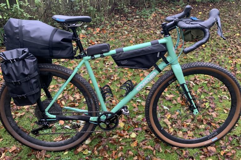Sonder Camino AL Apex 1 Hydraulic bike with bikepacking bags on pictured in a forest