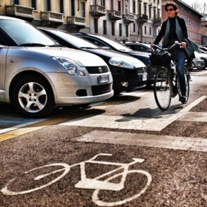 Cyclist passing parked cars in Milan (copyright Simon MacMichael)