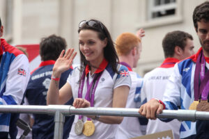 Victoria Pendleton waves from the Olympic parade bus (Image CC licensed DCMS:Flickr)