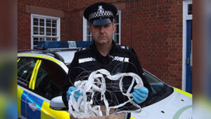 PC Simon Mortimer with wire found stretched across bike path (picture &ndash; Suffolk Constabulary)