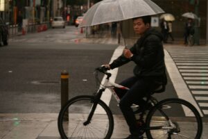 Osaka cyclist in rain (CC licensed by Akuppa John Wigham via Flickr)
