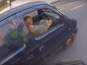 Van driver reading newspaper (image taken from YouTube).jpg