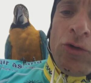 Michele Scarponi on a ride with Frankie the macaw (source Twitter).JPG
