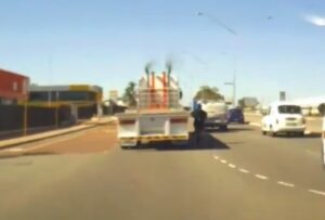 Cyclist hitches ride (taken from YouTube).jpg