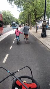 Girl holding hands with dad on cycle superhighway.jpg