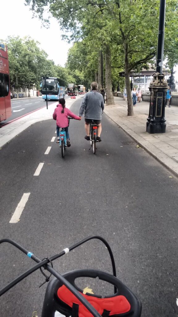 Girl holding hands with dad on cycle superhighway.jpg
