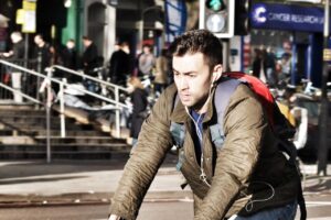 Cyclist with earbuds – copyright Simon MacMichael