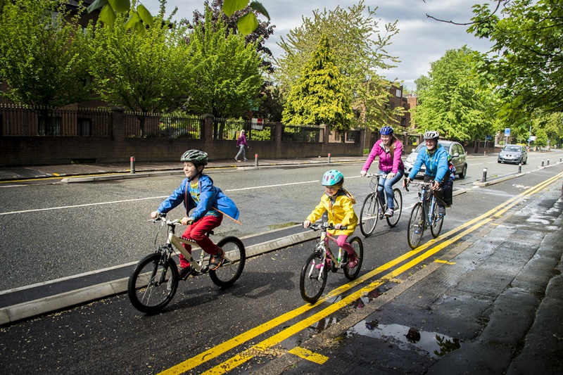 Family cycling along the Wilmslow Road Cycleway