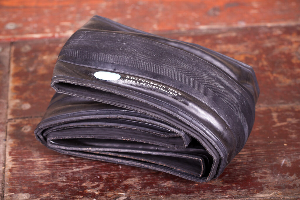 Compass 650B x 48 Switchback Hill Extralight TC tyre folded on wooden surface