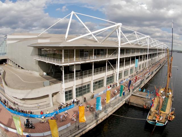 The 2010 Tour of Britain peloton races past London’s ExCel Centre (copyright Simon MacMichael)