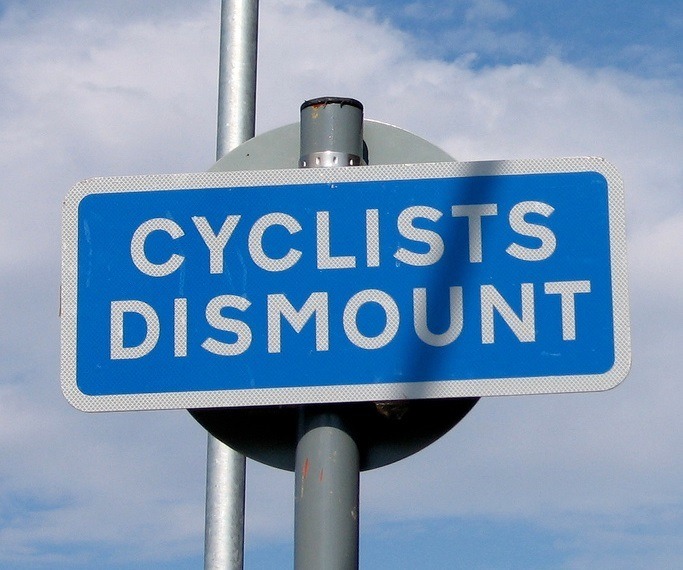 Cyclists dismount sign (CC licensed by Marcin Wichary via Flickr).jpg