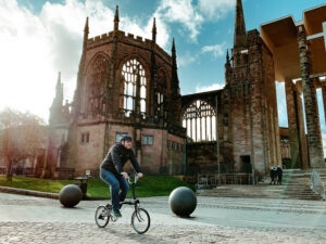 Coventry Bicycle Mayor Adam Tranter cycling past the city’s cathedral