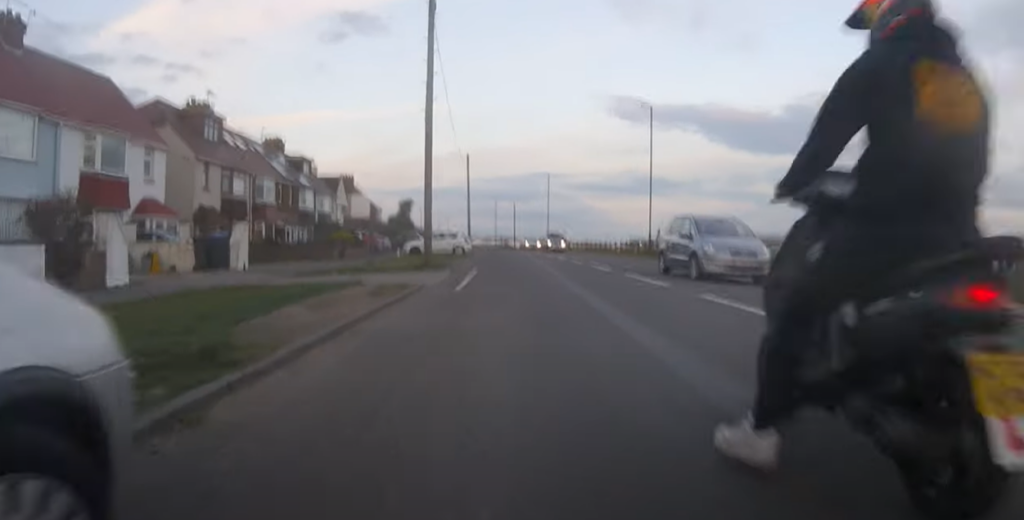Moped rider aims kick at cyclist