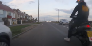Moped rider aims kick at cyclist