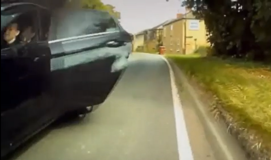 Reckless moment passenger hits cyclist by opening car door as driver overtakes