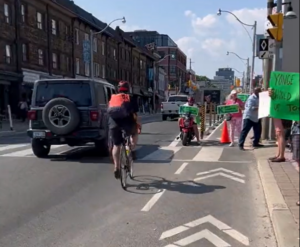 Bike lane protesters force cyclist into traffic (credit – Deborah Reid, Twitter)