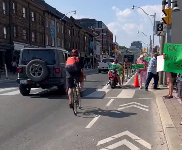 Bike lane protesters force cyclist into traffic (credit – Deborah Reid, Twitter)