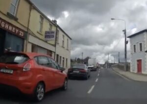 Cyclist filtering past slower-moving cars (Twitter: @CyclingInKK))