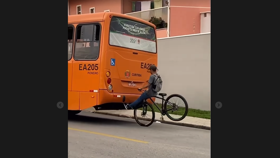 Cyclist in Brazil hangs onto back of bus with feet (curitibamilgraus, Instagram)
