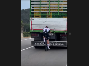 Felix Gross takes tow from lorry during training ride