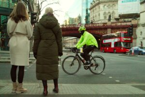 Cyclist in London with pedestrians in foreground – copyright Simon MacMichael