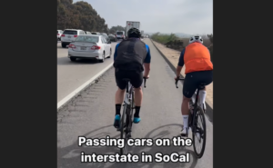 Cyclists, including Phil Gaimon, pass slow-moving traffic on Californian motorway
