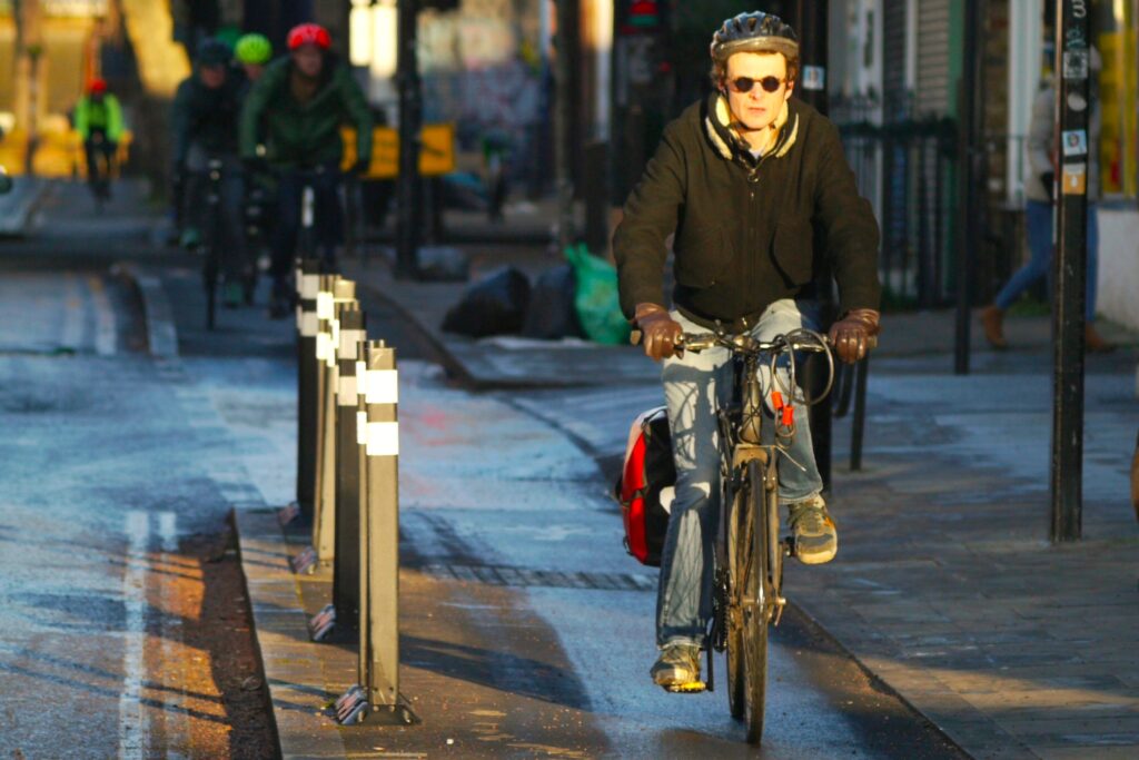 Cyclist in London cycle lane with bollards – copyright Simon MacMichael