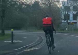 Irish cyclist riding on road next to shared use path and bollard (Important Season 620, Reddit)
