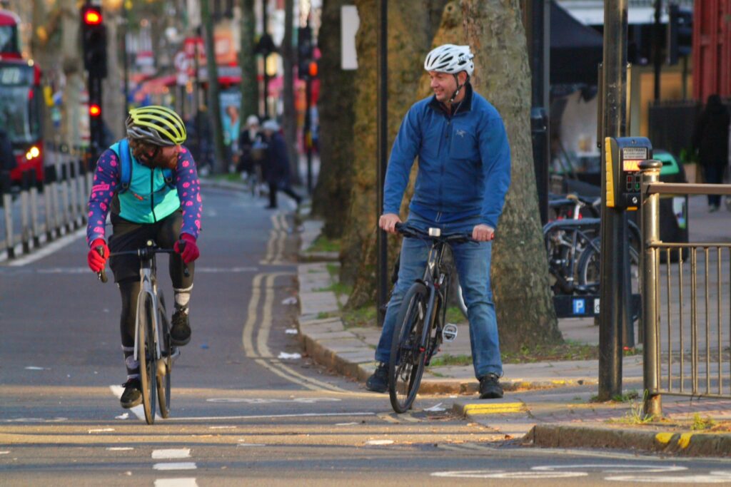 Cyclists in London talking in cycle lane – copyright Simon MacMichael