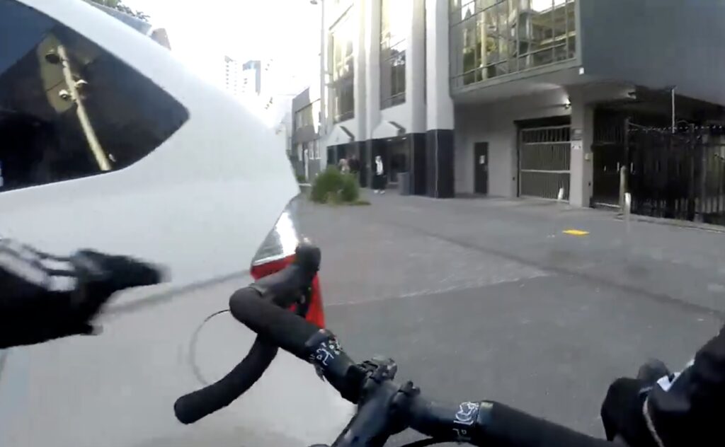 Cyclist opens car door of driver making illegal turn