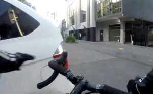 Cyclist opens car door of driver making illegal turn