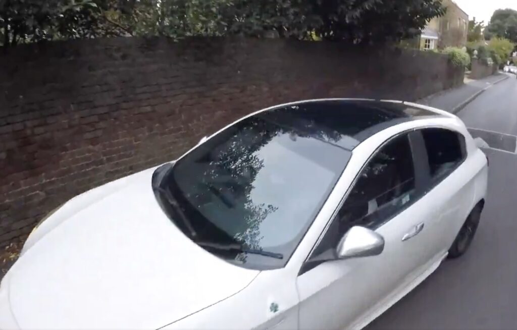 Driver mounts pavement to overtake cyclist
