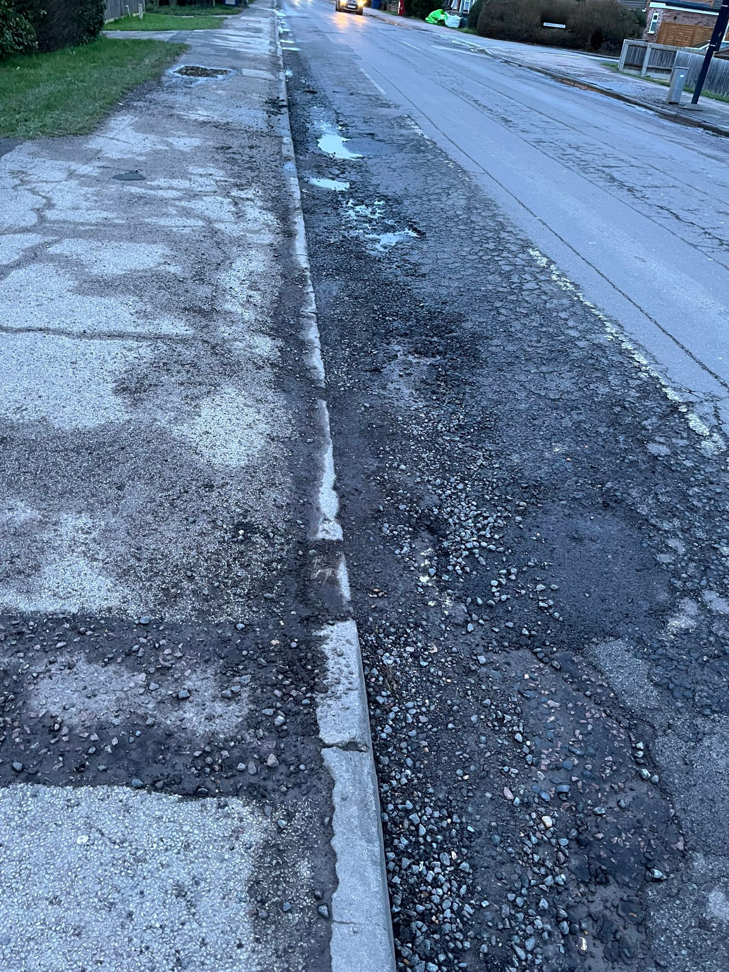Cherry Hinton Road cycle lane, Cambridge, filled with potholes and stones