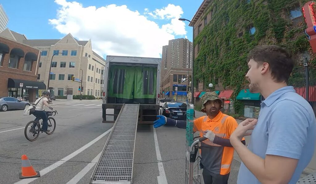 Cyclist rides up ramp of delivery lorry blocking bike lane in Minneapolis, Minnesota 3