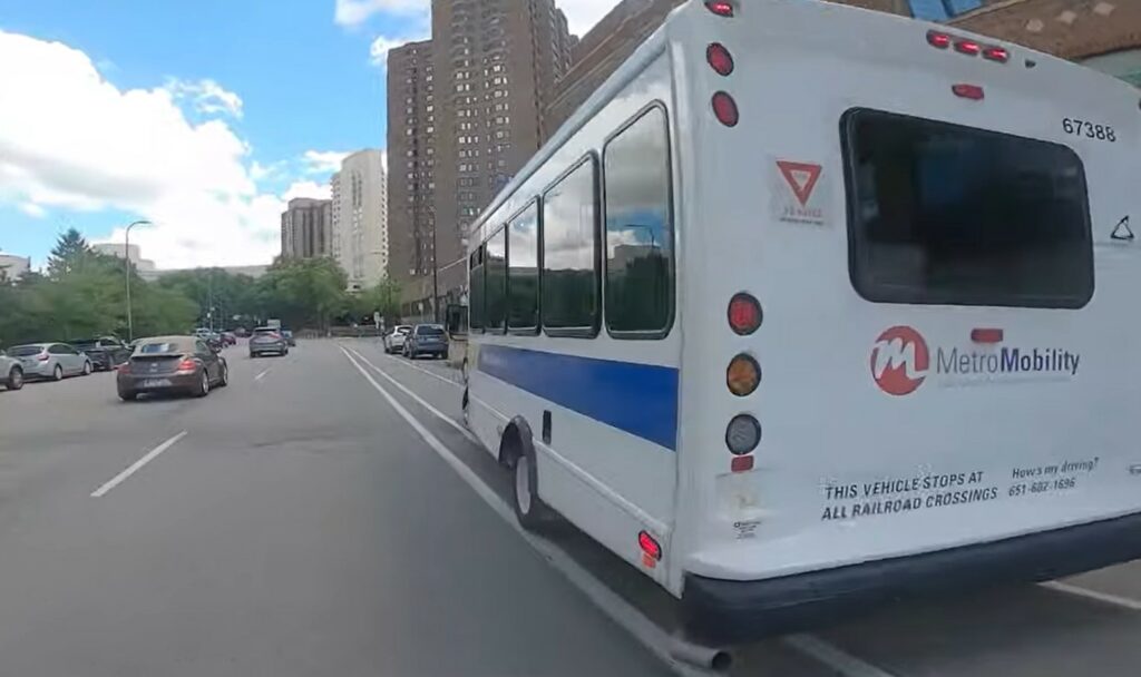 Cyclist rides up ramp of delivery lorry blocking bike lane in Minneapolis, Minnesota 4