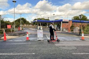 Voi e-scooter passing petrol station