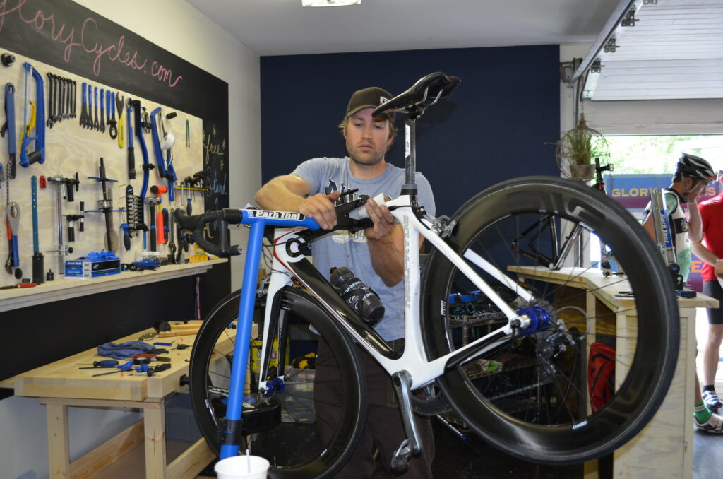 A bike mechanic works on a bike in a Park Tools workstand