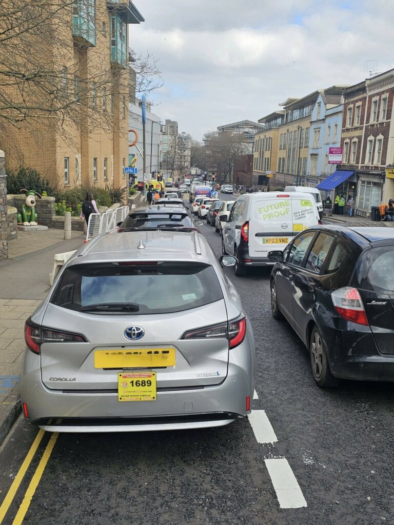 Cars parked in cycle lane outside BRI, Bristol