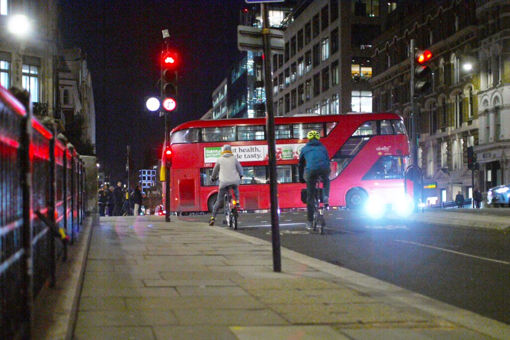 Cyclists in London at night stopped at red light