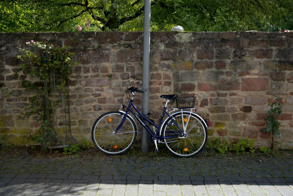 Bike leaning against pole on pavement