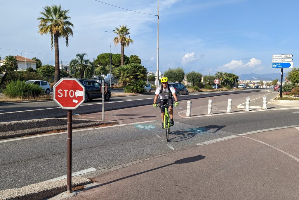 Nice-Antibes – Cycle path junction with rider (copyright Simon MacMichael)