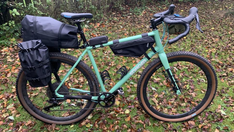 Sonder Camino AL Apex 1 Hydraulic bike with bikepacking bags on pictured in a forest