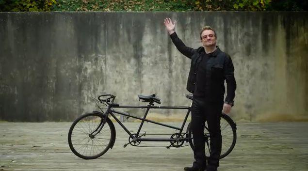 Bono and bike (source (RED) YouTube video still).JPG