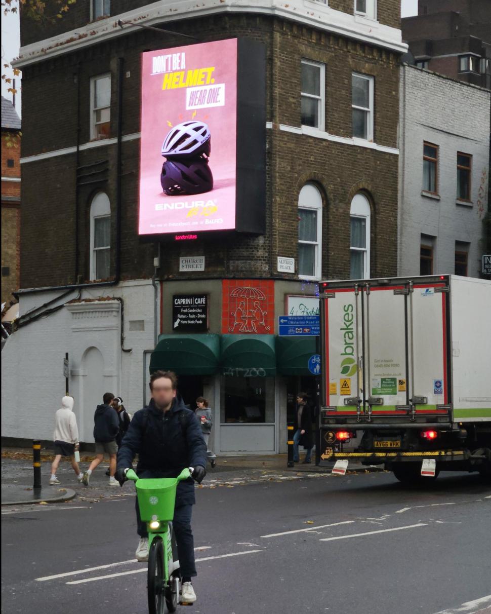 Cyclist on Lime Bike riding past Endura helmet campaign
