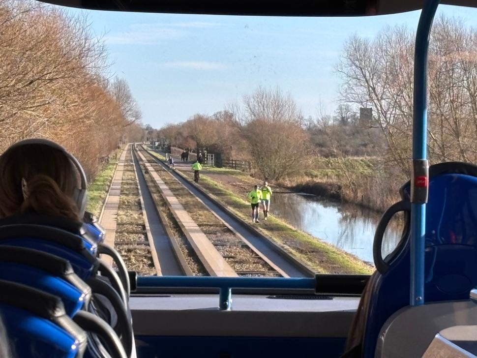Cyclists and runners on DIY path next to Cambridgeshire Guided Busway