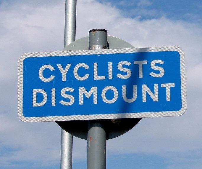 Cyclists dismount sign (CC licensed by Marcin Wichary via Flickr).jpg