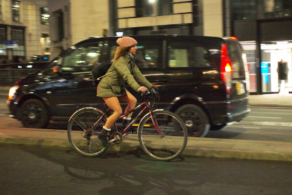 Female cyclist in London casual winter clothing on hybrid bike - copyright Simon MacMichael