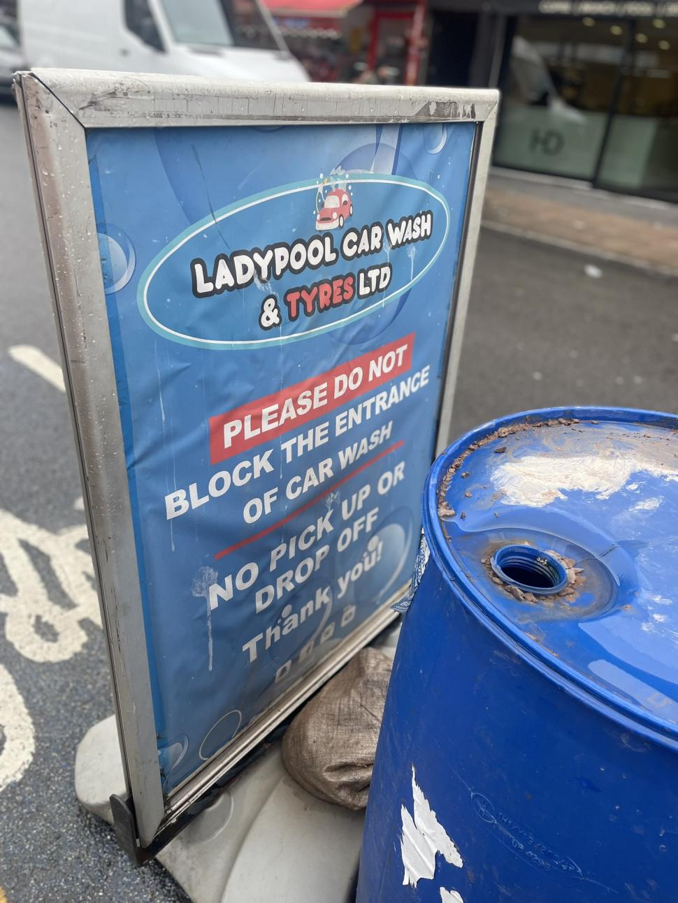 Car wash sign in cycle lane (@naomi_fisher/Twitter)