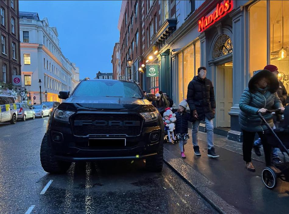 Ford Ranger pick-up on street next to pedestrians