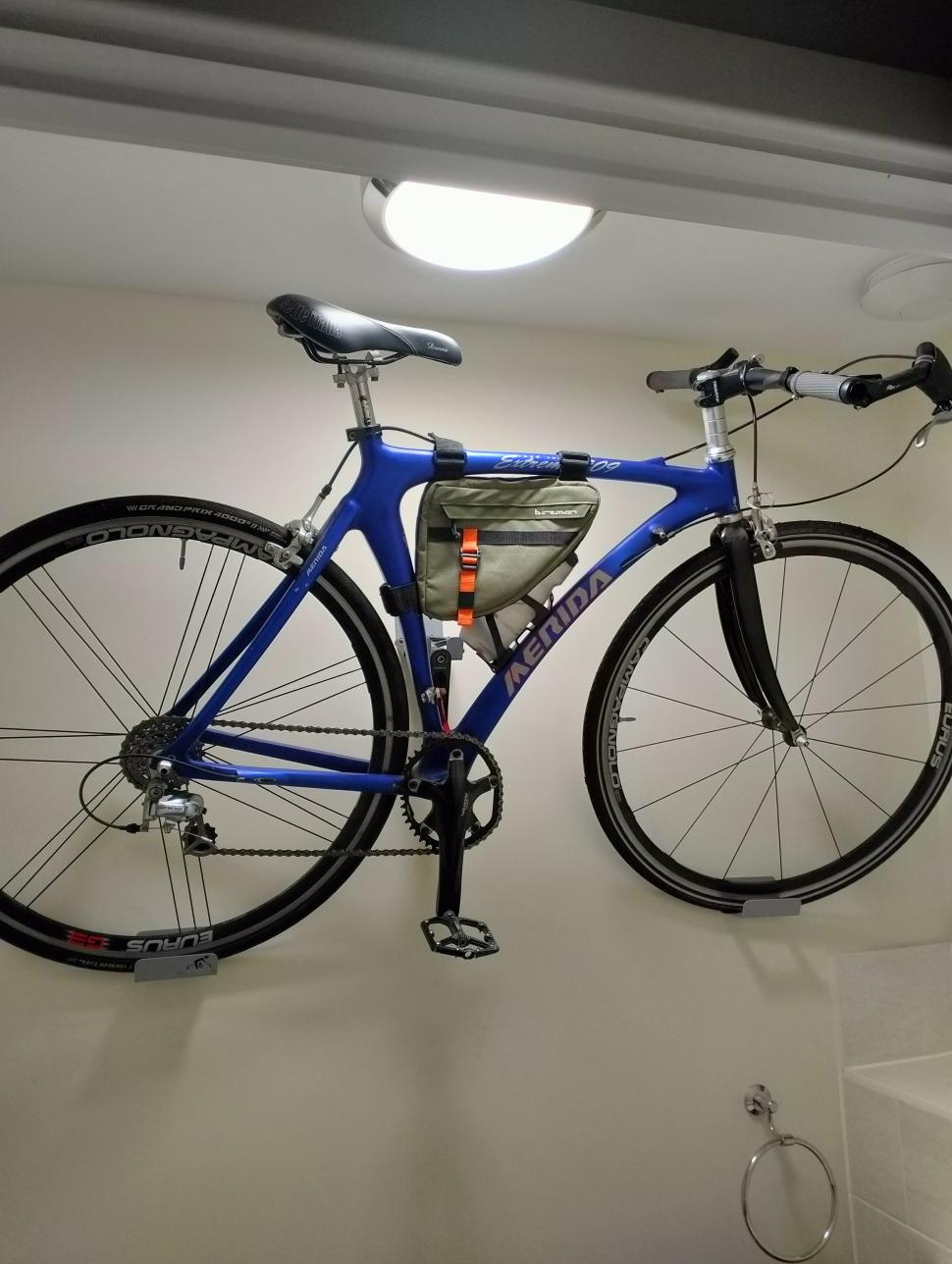 Carbon bike hanging on bathroom wall